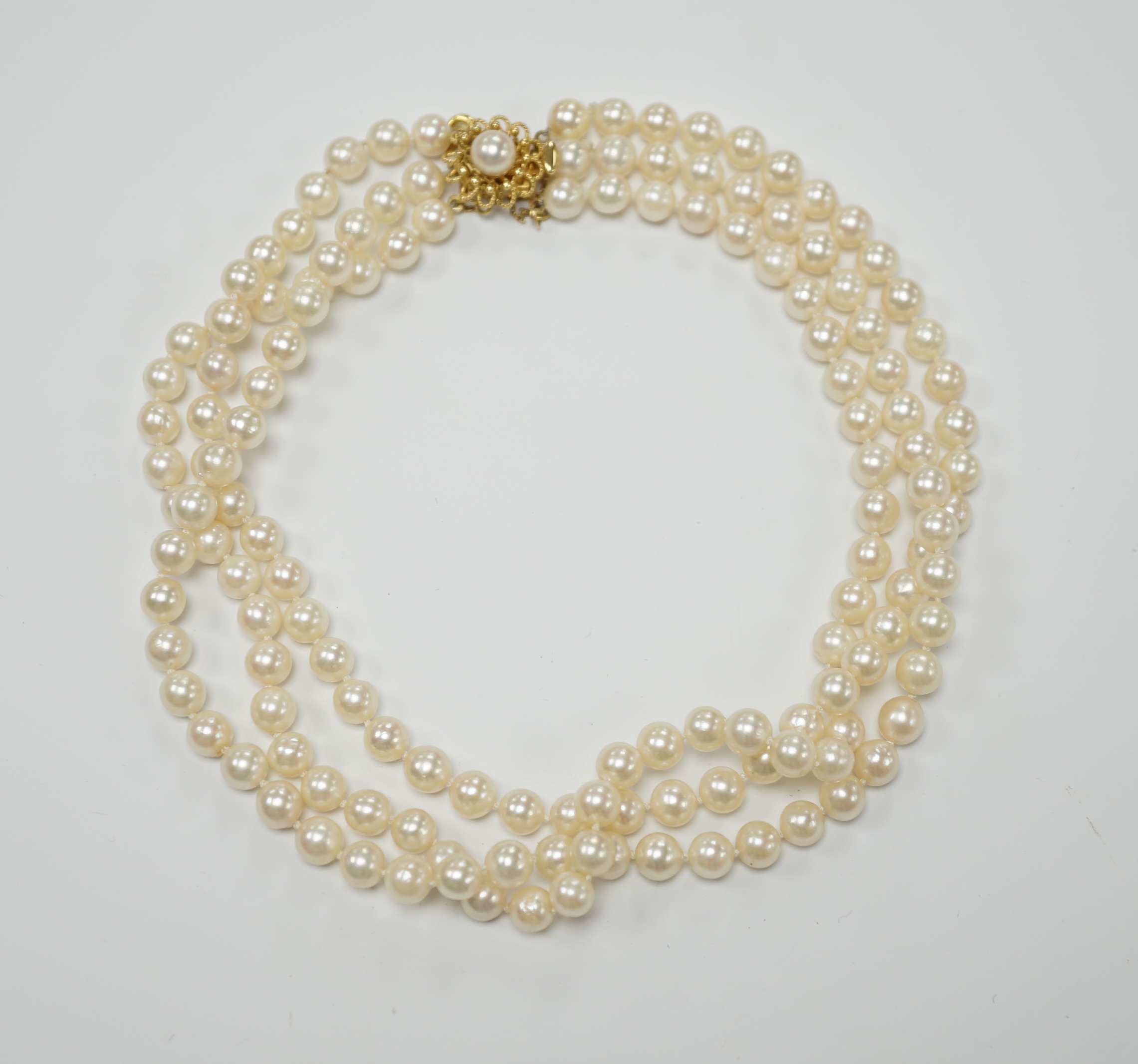 A triple strand cultured pearl set choker necklace, with 750 yellow metal and cultured pearl set clasp, 35cm.